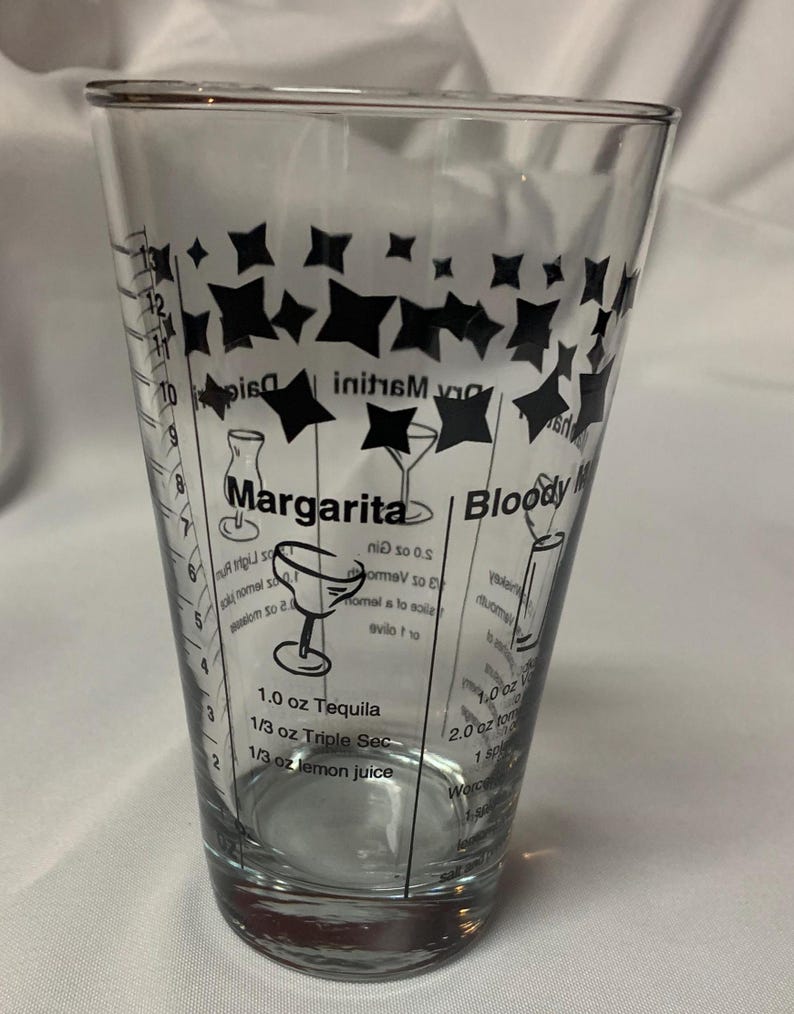 Puede incluir: Un vaso medidor de vidrio transparente con dise&ntilde;os de estrellas negras e instrucciones para hacer una margarita y un bloody mary. La receta de la margarita requiere 3 cl de tequila, 1 cl de triple sec y 1 cl de jugo de lim&oacute;n. La receta del bloody mary requiere 3 cl de vodka, 6 cl de jugo de tomate, 1 cucharadita de salsa Worcestershire y 1/2 cucharadita de salsa picante.