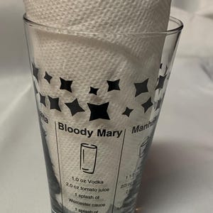 Puede incluir: Un vaso medidor de vidrio transparente con dise&ntilde;os de estrellas negras y una receta de Bloody Mary impresa en el lateral. La receta incluye 3 cl de vodka, 6 cl de jugo de tomate, 1 chorrito de salsa Worcestershire, 1 chorrito de jugo de lim&oacute;n, sal y pimienta.