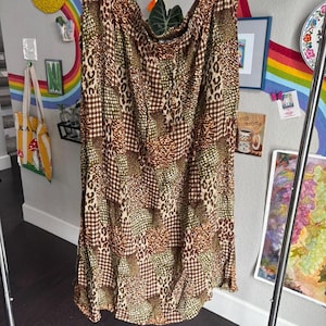 May include: A brown, green, and beige maxi skirt with a patchwork design featuring leopard print, plaid, and geometric patterns.