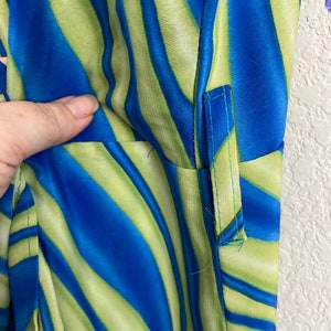 May include: Close-up of a blue and green striped fabric with a seam down the side.