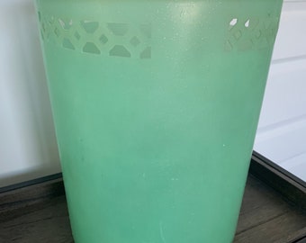 May include: A light green plastic trash can with a decorative cutout design around the top rim.