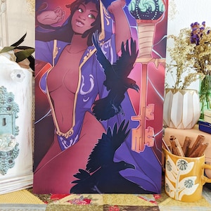 May include: Art print featuring a woman in a purple robe with gold accents, holding a staff with a glowing orb. Two black ravens are in flight. The background is a gradient of red and purple with key-shaped designs.
