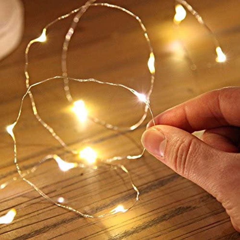 Peut inclure: Une guirlande de lumi&egrave;res LED blanches chaudes avec un fil de cuivre. Les lumi&egrave;res sont enfil&eacute;es dans un motif al&eacute;atoire et sont &eacute;clair&eacute;es.
