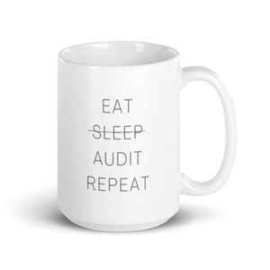 May include: White ceramic coffee mug with black text that reads "EAT SLEEP AUDIT REPEAT".