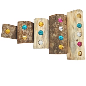 May include: Six wooden logs with different colored glass gems embedded in them. The logs are arranged in a staggered pattern, with the largest log at the bottom and the smallest log at the top.