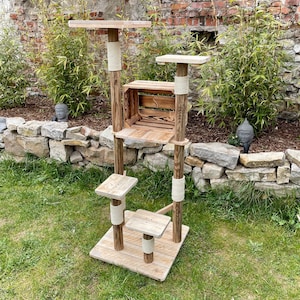 May include: A wooden cat tree with multiple platforms and scratching posts. The tree is wrapped in natural rope and has a wooden crate on the middle platform.