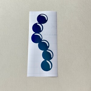 May include: A sticker sheet with a design of a row of seven blue circles, each circle slightly overlapping the next.
