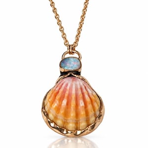 May include: A gold chain necklace featuring a pendant with a natural orange and yellow scallop shell encased in a gold setting, topped with a small, oval, iridescent blue opal stone. The pendant hangs from a delicate gold link chain.