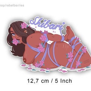 May include: A sticker featuring a woman tied up with purple rope and surrounded by pink flowers. The sticker is 5 inches wide and 3.15 inches tall. The text "Shibari" is written in purple on the sticker. The sticker is designed by Kinky Karrot.