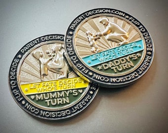 May include: Two gold-colored coins with black rims. The coins have a sunburst design with the text "Parent Decision Coin Flip to Decide" on the outer rim. One coin has the text "Let Fate Decide Who's Turn Daddy's Turn" and the other coin has the text "Let Fate Decide Who's Turn Mummy's Turn".
