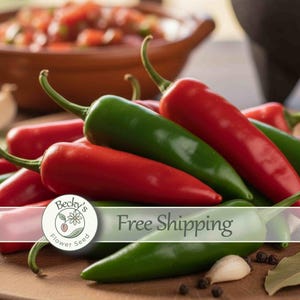 May include: A pile of fresh chili peppers in vibrant shades of red and green, featuring smooth, tapered skins and green stems. The peppers are arranged in a cluster, with some individual cloves of garlic and black peppercorns scattered nearby.