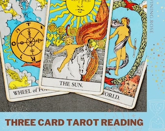May include: Three tarot cards, The Wheel of Fortune, The Sun, and The World, are laid out on a gray surface. The cards are colorful and feature traditional tarot imagery.