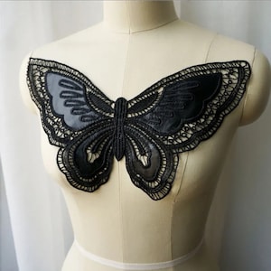 May include: Black lace butterfly applique with a satin-like finish. The applique is perfect for adding a touch of elegance to clothing, accessories, or home decor projects.