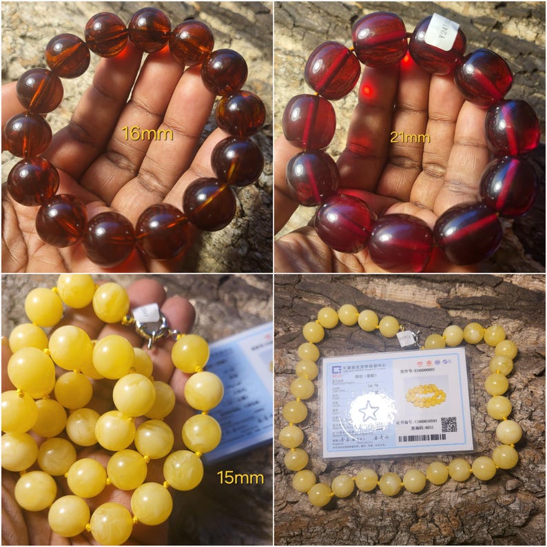 May include: Three amber bead necklaces, one each in yellow, red, and brown. The beads are round and smooth. The necklaces are displayed on a wooden surface. The yellow necklace is 15mm in diameter, the red necklace is 21mm in diameter, and the brown necklace is 16mm in diameter.