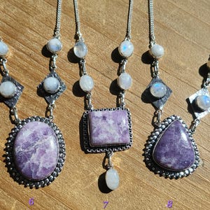 Puede incluir: Tres collares de plata con colgantes de piedra lunar y lepidolita lavanda. Los collares presentan una variedad de formas de colgantes, incluyendo ovalado, cuadrado y gota.