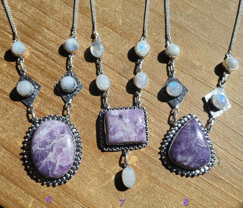 Puede incluir: Tres collares de plata con colgantes de piedra lunar y lepidolita lavanda. Los collares presentan una variedad de formas de colgantes, incluyendo ovalado, cuadrado y gota.