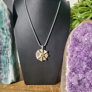May include: A silver chain necklace with a gold pendant featuring a heart and the words "walk in the light" on a circular background.