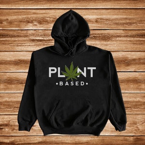 May include: Black hooded sweatshirt with a white graphic that says "PLANT BASED."  A green marijuana leaf is in the middle of the text.