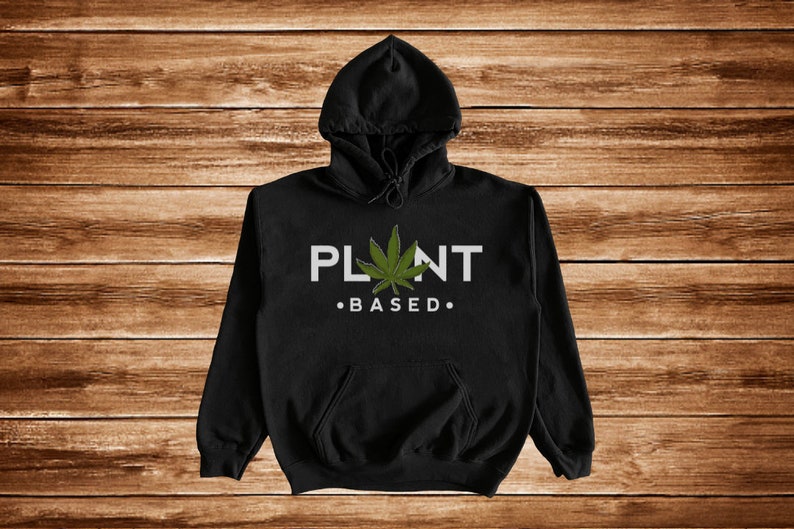 May include: Black hooded sweatshirt with a white graphic that says "PLANT BASED."  A green marijuana leaf is in the middle of the text.