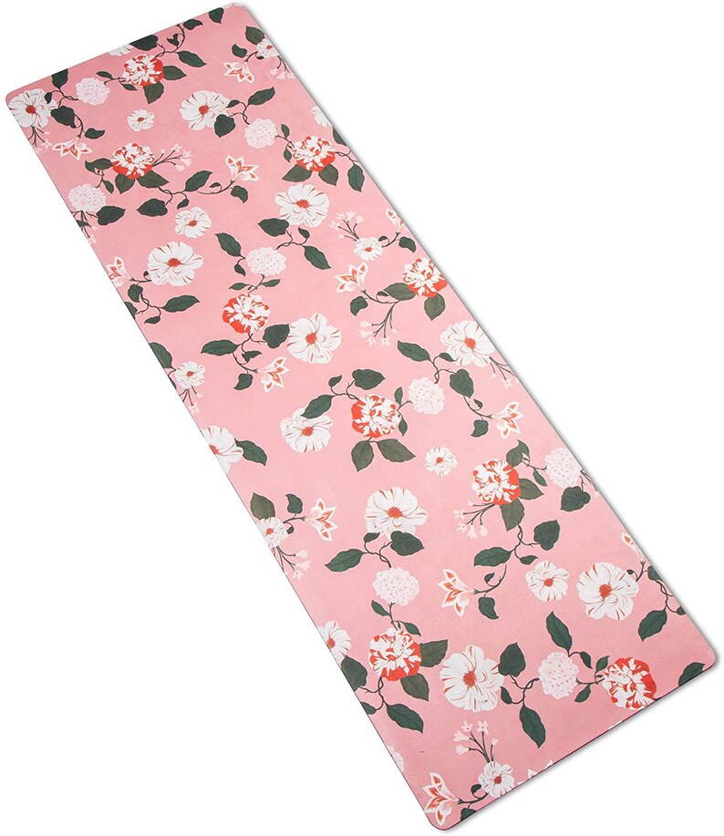 May include: A pink yoga mat with a floral pattern featuring white and red flowers. The mat has a textured surface.