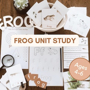 May include: Educational materials for a frog unit study, including flashcards, worksheets, and wooden letter blocks spelling "FROG". The materials are arranged on a wooden surface, with a small succulent plant and a magnifying glass.