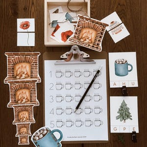 May include: A set of educational materials for children featuring a fireplace, a mug of hot chocolate, a Christmas tree, and a counting activity. The materials are printed on white cardstock and feature colorful illustrations.