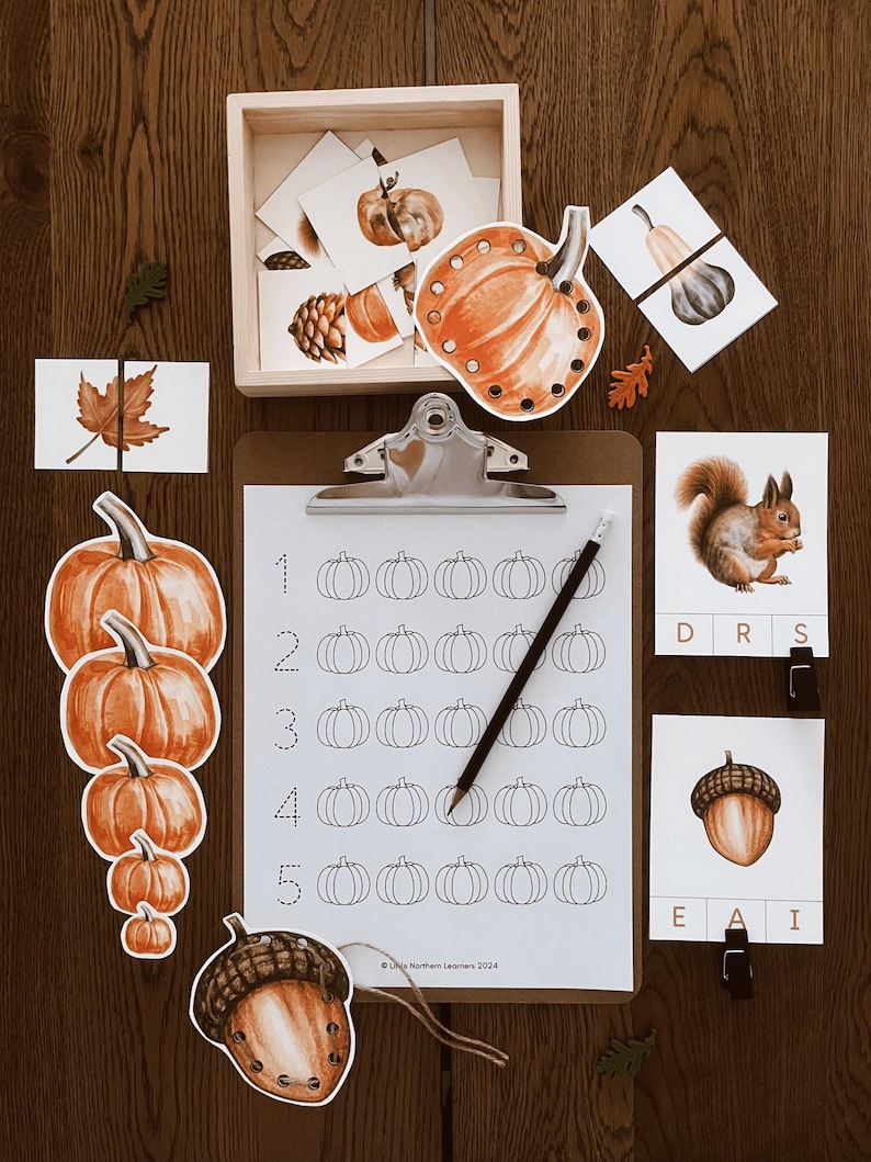 May include: A set of printable fall-themed educational activities for kids. The set includes a counting activity with pumpkins, a matching game with acorns, a matching game with gourds, and a word puzzle with the word "DRS" and "EAI".