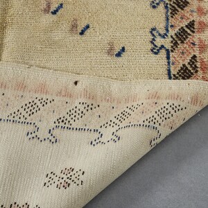 a close-up view of a beige rug with a pattern of small dots and lines, as well as a section of a larger rug with a similar pattern.