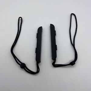 Puede incluir: Dos mandos Nintendo Switch Joy-Con negros con correas de mu&ntilde;eca negras.
