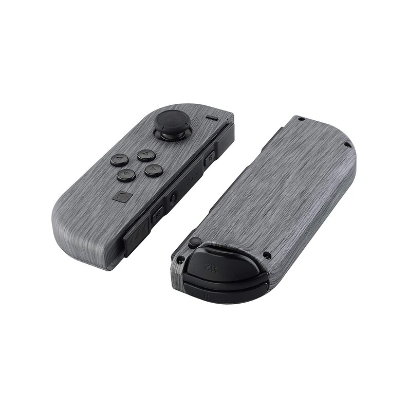 Może przedstawiać: Para kontroler&oacute;w Nintendo Switch Joy-Con w kolorze szarym z wzorem drewna. Lewy Joy-Con ma przyciski i joystick, a prawy Joy-Con ma czarny przycisk.