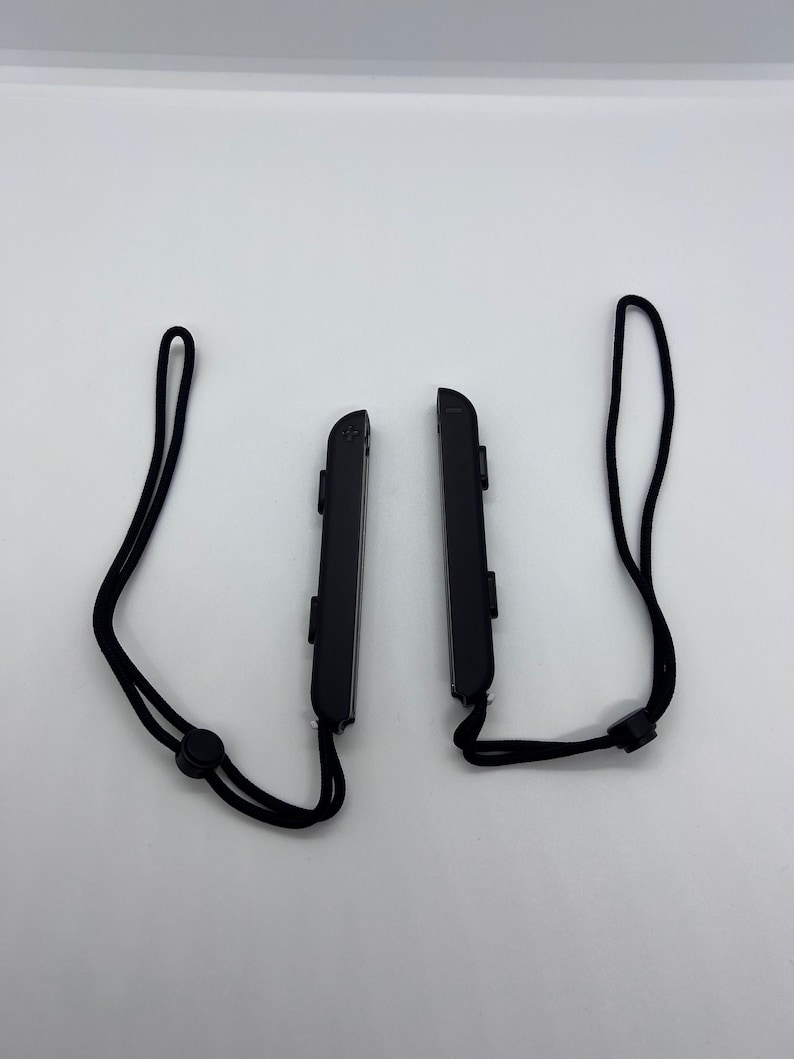 Puede incluir: Dos mandos Nintendo Switch Joy-Con negros con correas de mu&ntilde;eca negras.