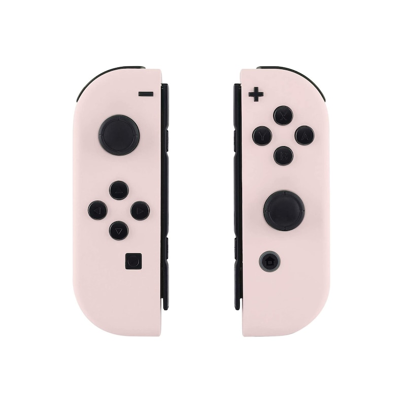 May include: A pair of pink Nintendo Switch Joy-Con controllers with black buttons and a black border. The controllers are separated and show the front view.