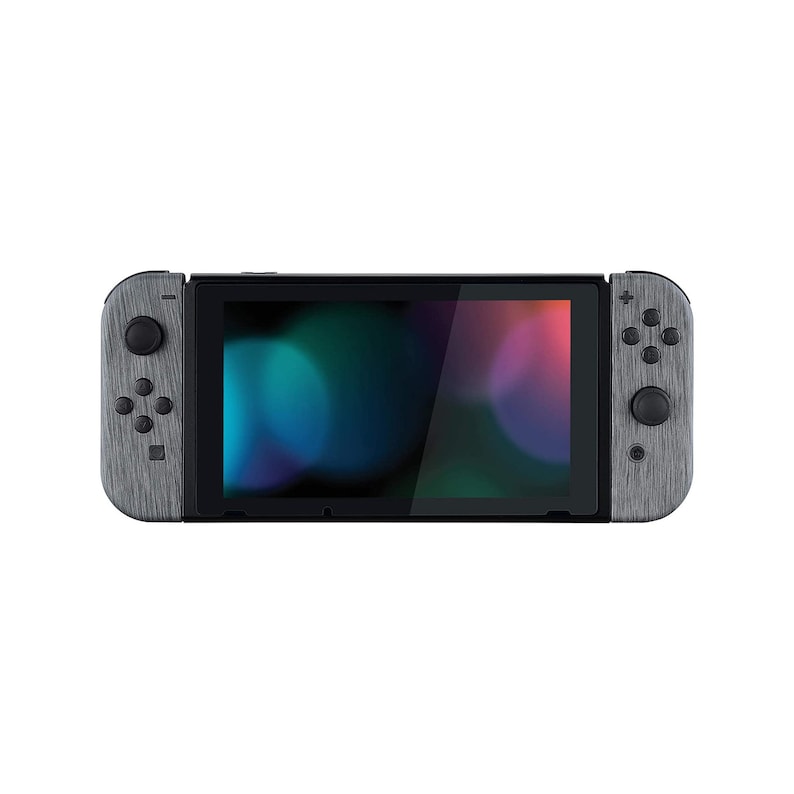 Może przedstawiać: Szara konsola Nintendo Switch z wzorem drewna po bokach. Konsola jest w trybie przenośnym, a ekran wyświetla kolorowe abstrakcyjne tło.