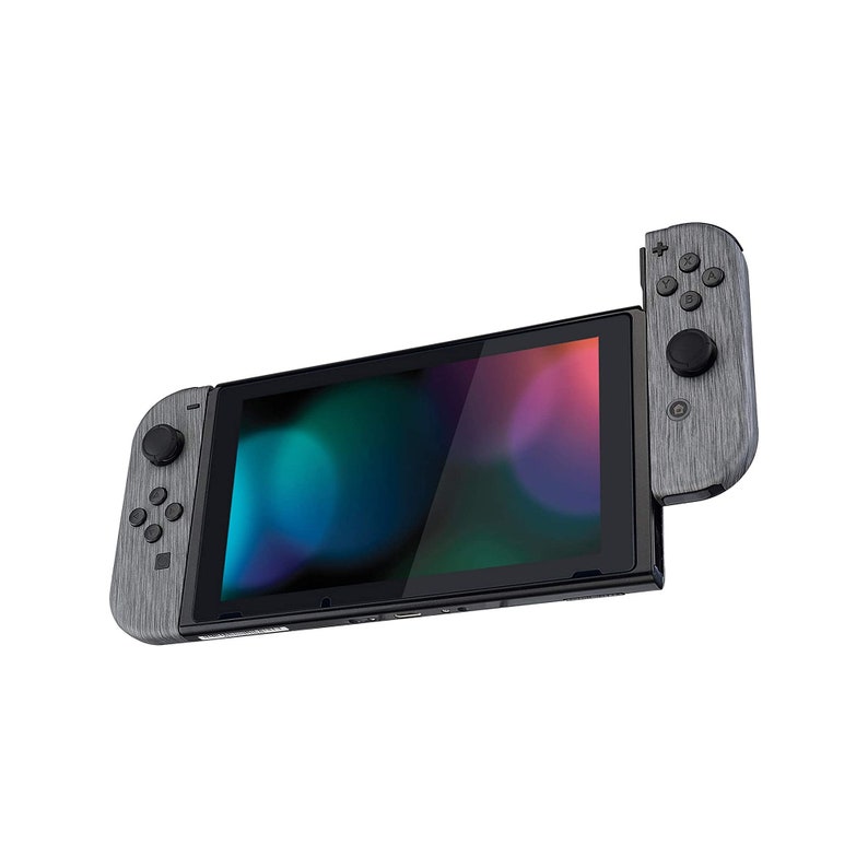 Może przedstawiać: Szara konsola Nintendo Switch z wzorem imitującym drewno. Konsola jest w trybie przenośnym, a na ekranie wyświetlany jest kolorowy abstrakcyjny tło.