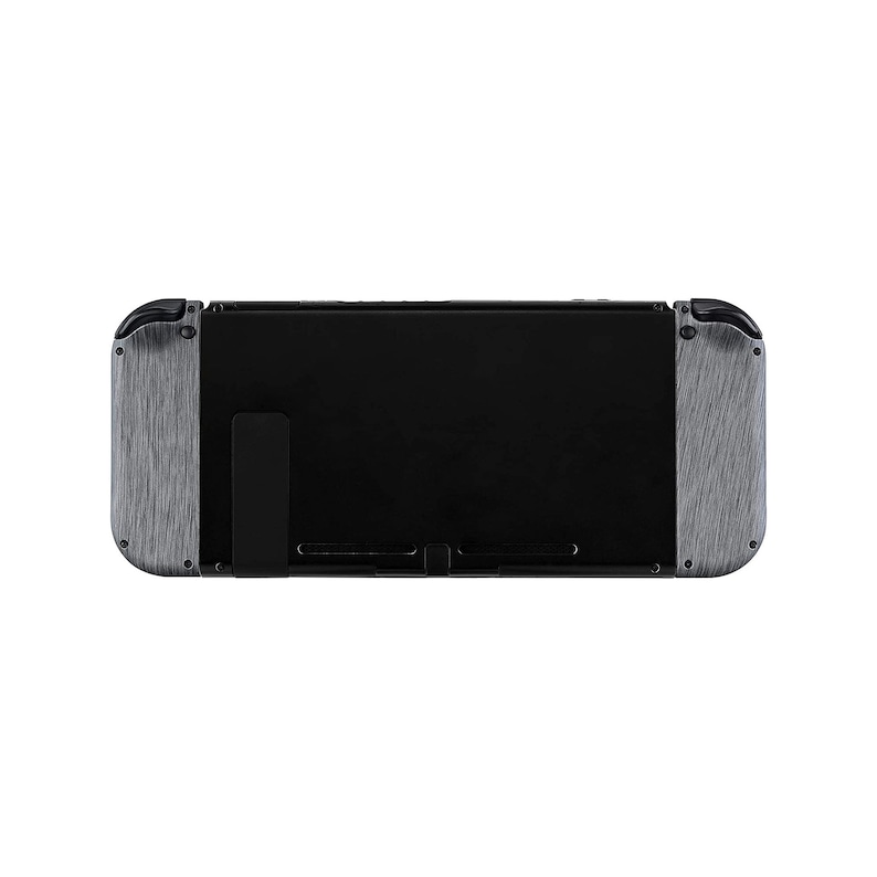 Może przedstawiać: Czarna konsola Nintendo Switch z szarymi, szczotkowanymi metalowymi płytkami. Konsola jest w trybie przenośnym.