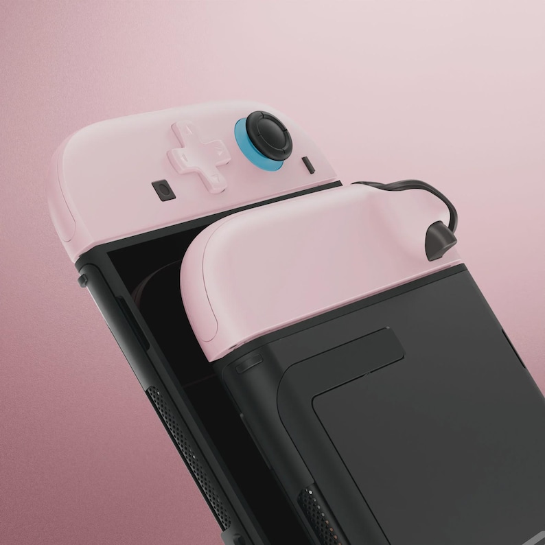 May include: A pink and black gaming controller with a D-pad, buttons, and a joystick. The controller has a sleek design with a black body and pink accents. The joystick has a blue ring around it.