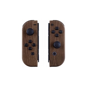 Op de afbeelding: Twee bruine Joy-Con controllers met houtnerftextuur voor een Nintendo Switch console. Elke controller heeft zwarte knoppen en joysticks. De controllers staan tegen een witte achtergrond.