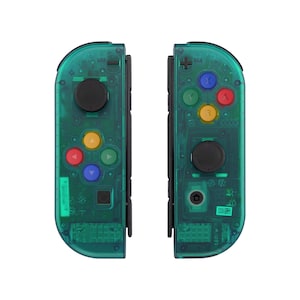 May include: A pair of green transparent Nintendo Switch Joy-Con controllers with black buttons. The controllers have a variety of coloured buttons, including red, yellow, blue, and green.