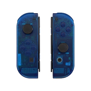 May include: A pair of transparent blue Nintendo Switch Joy-Con controllers. The controllers have black buttons and a clear design.