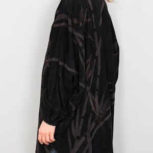 Puede incluir: Chaqueta negra de manga larga con un estampado marr&oacute;n oscuro similar al bamb&uacute;. La chaqueta tiene un cuello alto y un corte holgado. Las mangas son largas y terminan en la mu&ntilde;eca. La chaqueta est&aacute; hecha de una tela suave y texturizada.