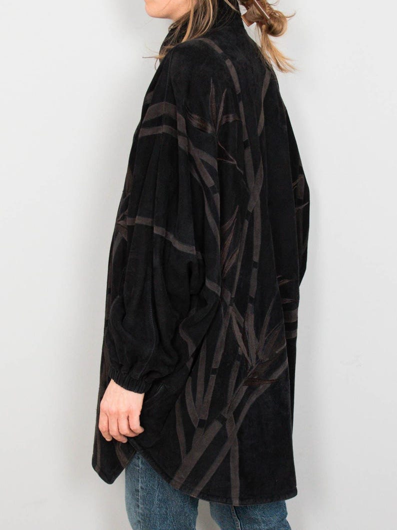 Puede incluir: Chaqueta negra de manga larga con un estampado marr&oacute;n oscuro similar al bamb&uacute;. La chaqueta tiene un cuello alto y un corte holgado. Las mangas son largas y terminan en la mu&ntilde;eca. La chaqueta est&aacute; hecha de una tela suave y texturizada.