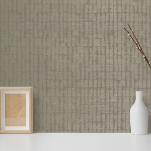 May include: A beige textured wallpaper with a subtle pattern. The wallpaper is displayed on a white surface with a picture frame, a cactus in a white pot, and a vase with branches and two white ceramic vases.