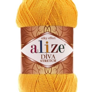 以下が含まれることがあります： 鮮やかな黄色のAlize Diva Stretch糸の玉。ラベルにはブランド名と製品の詳細が様々な色で表示されています。糸はきつく巻かれており、繊維の質感がわかります。「silky effect」の文字も確認できます。