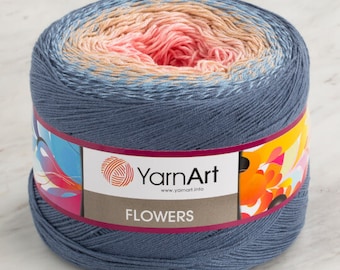May include: A ball of blue, peach, and pink yarn with a label that reads "YarnArt" and "FLOWERS" on a white surface.