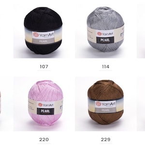 Puede incluir: Ocho ovillos de hilo YarnArt Pearl en varios colores, incluyendo blanco, negro, plateado, rojo, beige, rosa, marr&oacute;n y marfil. Cada ovillo tiene una etiqueta con el nombre de la marca "YarnArt" y el tipo de hilo "PEARL".