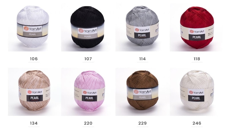 Puede incluir: Ocho ovillos de hilo YarnArt Pearl en varios colores, incluyendo blanco, negro, plateado, rojo, beige, rosa, marr&oacute;n y marfil. Cada ovillo tiene una etiqueta con el nombre de la marca "YarnArt" y el tipo de hilo "PEARL".