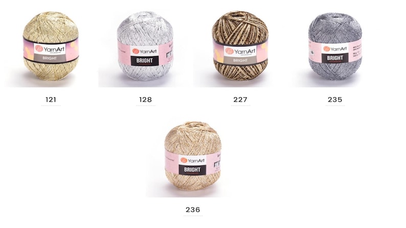 Op de afbeelding: Vijf bollen garen in verschillende kleuren, waaronder goud, zilver en bruin. Elke bol heeft een label met de tekst "YarnArt BRIGHT".