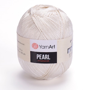 Puede incluir: Un ovillo de hilo blanco YarnArt Pearl. La etiqueta dice "YarnArt Pearl" y "www.yarnart.info".
