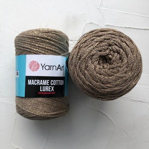 May include: Two spools of brown macrame cord with gold glitter thread. The label reads "YarnArt Macrame Cotton Lurex www.yarnart.info"