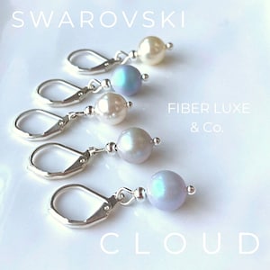 Pode incluir: Cinco ganchos de brinco de prata com uma pérola branca e uma pérola azul iridescente em cada gancho. O texto "FIBER LUXE & Co." e "CLOUD" é visível na imagem.